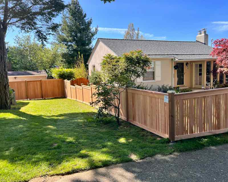Cedar privacy fence along a front yard and sidewalk